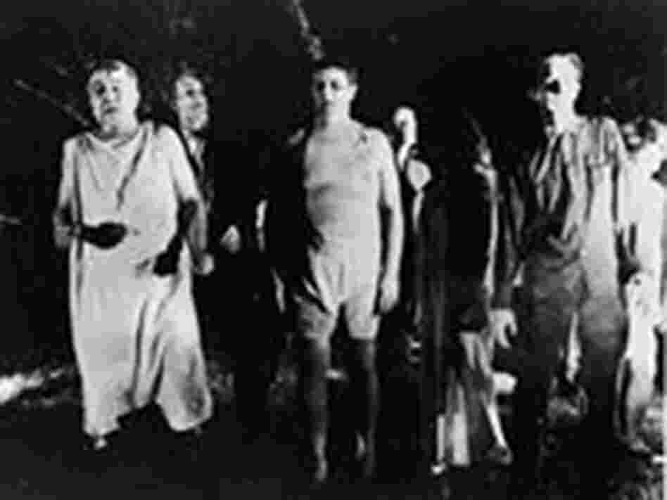A line of undead 'zombies' walk through a field in the night in a still from the film, 'Night Of The A line of undead 'zombies' walk through a field in the night in a still from the film, 'Night Of The