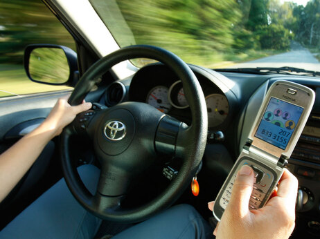 A driver uses a cell phone, Tuesday, Sept. 8, 2009, in Freeport, Maine. (AP Photo/Robert F. Bukaty)
