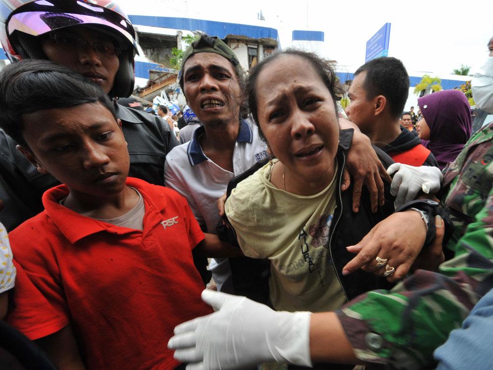 Indonesians cry in mourning after identifying a dead relative at a hospital in Padang, West Sumatra, on October 1, 2009, after a 7.6-magnitude earthquake hit the area. (Bay Ismoyo/AFP/Getty Images)