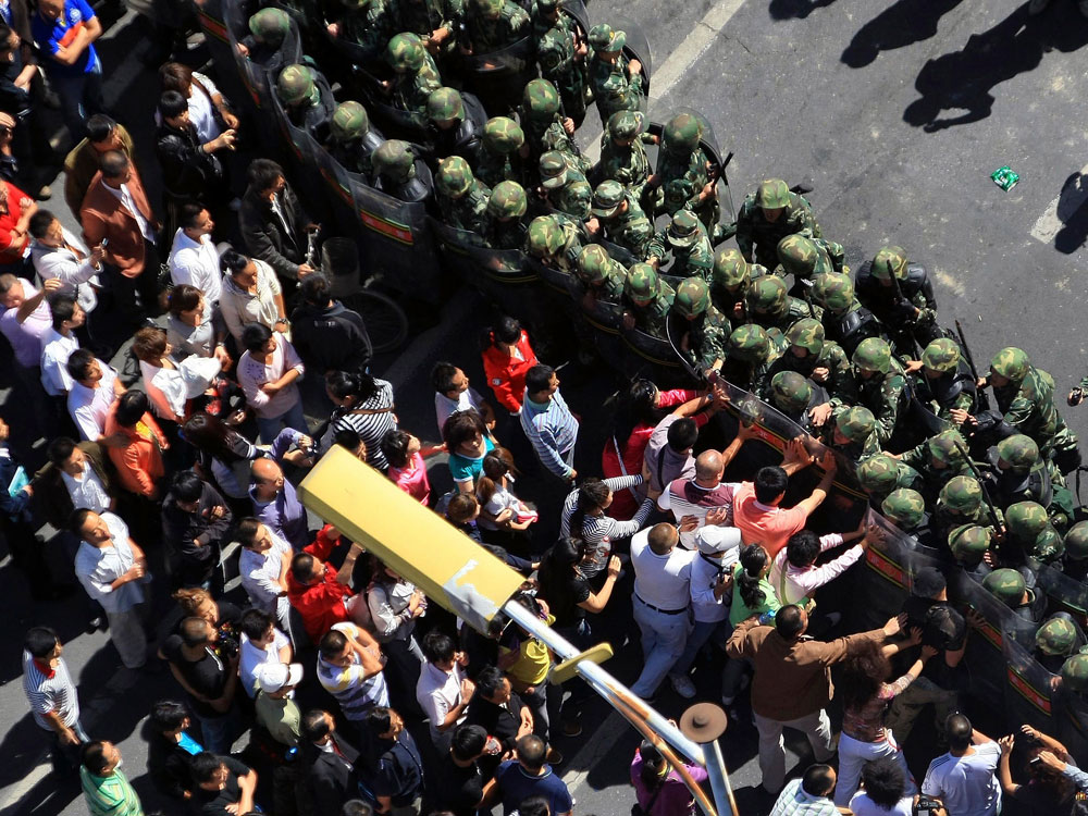 Chinese protesters push against a line of Chinese paramilitary police on the streets of Urumqi in western China's Xinjiang province, Thursday, Sept. 3, 2009. Chinese residents protested deteriorating public safety Thursday after reported syringe attacks in the city where ethnic rioting in July killed nearly 200 people. (AP Photo)