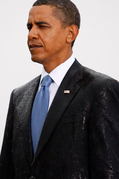 Wet President Barack Obama stands at attention at Pentagon 9/11 memorial.