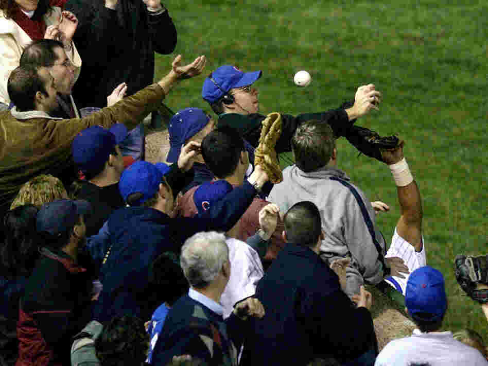 In this Oct. 14, 2003 file photo, Chicago Cubs left fielder Moises Alou's arm is seen reaching into 
