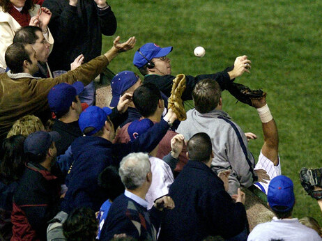 In this Oct. 14, 2003 file photo, Chicago Cubs left fielder Moises Alou's arm is seen reaching into the stands, at right, unsuccessfully for a foul ball along with a fan identified as Steve Bartman, left, wearing headphones, glasses and Cubs hat, during the eighth inning against the Florida Marlins in Game 6 of the National League Championship Seriesin Chicago. (AP Photo/Morry Gash, File)