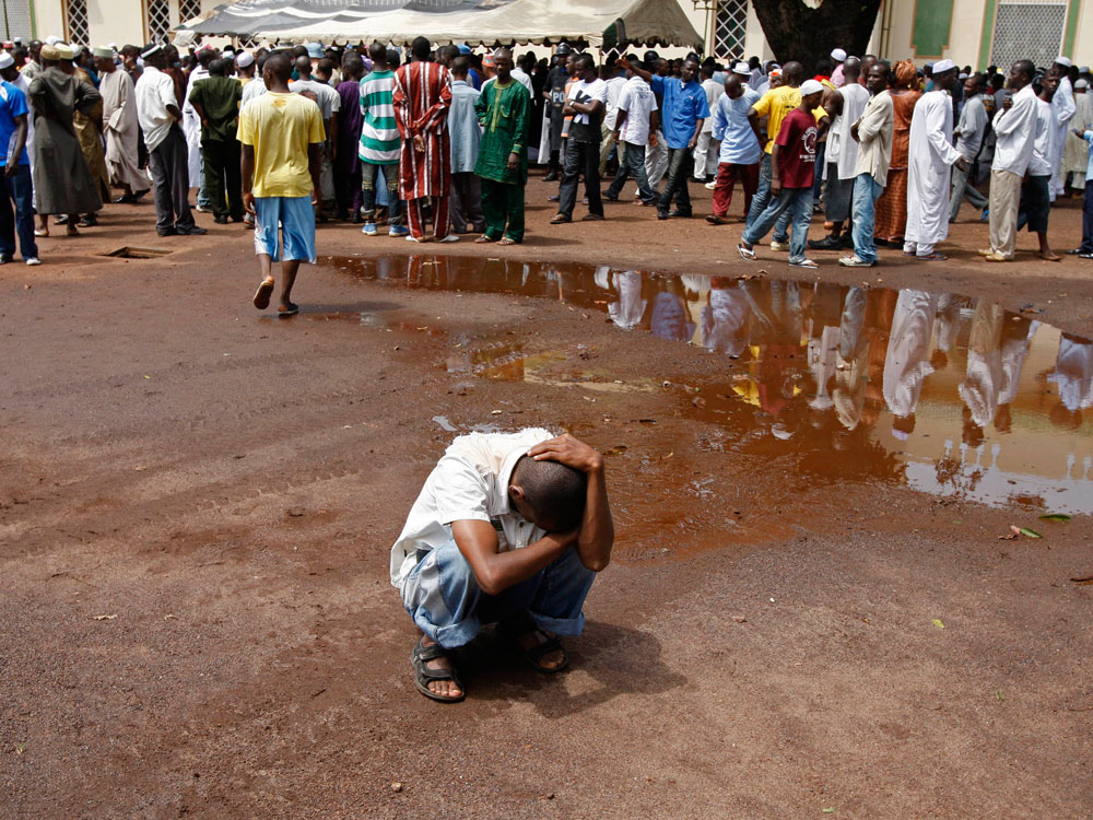 A man reacts after he and others searched for the bodies of family members and friends in Conakry, Guinea,  on Oct. 2, 2009. Guinea's independence celebrations were somber Friday as the government prepared to bury 57 people killed when troops fired live ammunition at a pro-democracy rally on Sept. 28. (AP Photo/Schalk van Zuydam) 
