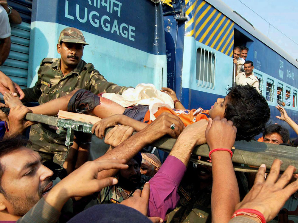 An injured person is rescued after a Goa Express train, unseen, rammed into the stationary Mewar Express train, background, near Agra, about 130 miles southeast of New Delhi, India, Wednesday, Oct. 21, 2009. (AP Photo) 