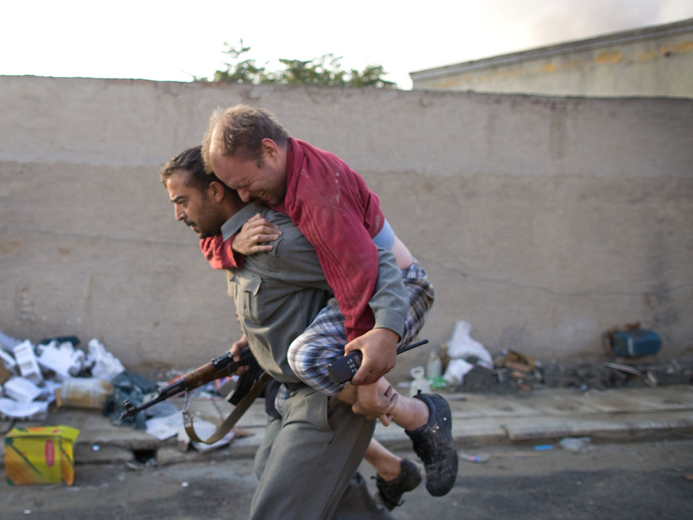 A German man with a broken foot is carried away from the scene of a suicide bomb attack on an international guest house October 28, 2009, in Kabul, Afghanistan. Taliban militants killed six U.N. foreign staff in the early morning assault raising serious issues about security before the Presidential run-off election in less tham two weeks time. Rockets were also fired at the Serena hotel but no injuries were reported. (Photo by Paula Bronstein /Getty Images) 