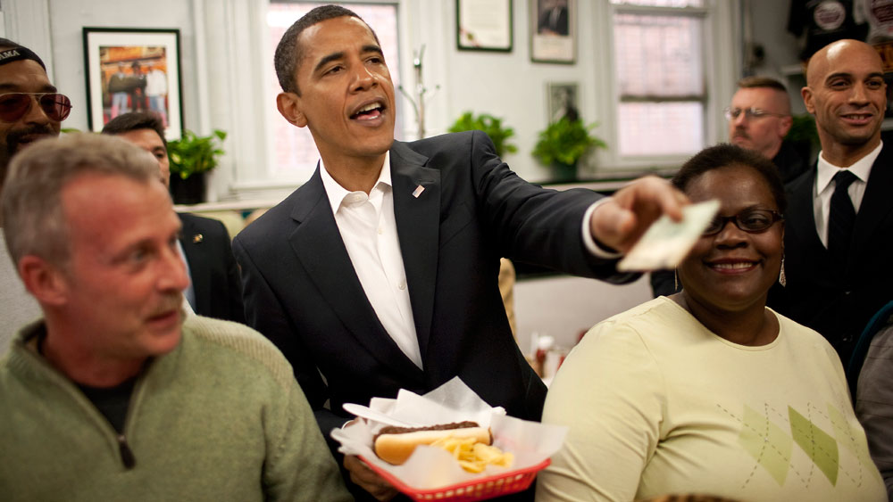  President-elect Barack Obama pays for his lunch at Ben's Chili Bowl January 10, 2009 in Washington, DC. Obama ordered a chili half smoke at the Washington landmark during a lunch with the DC mayor. (Photo by Joshua Roberts-Pool/Getty Images)