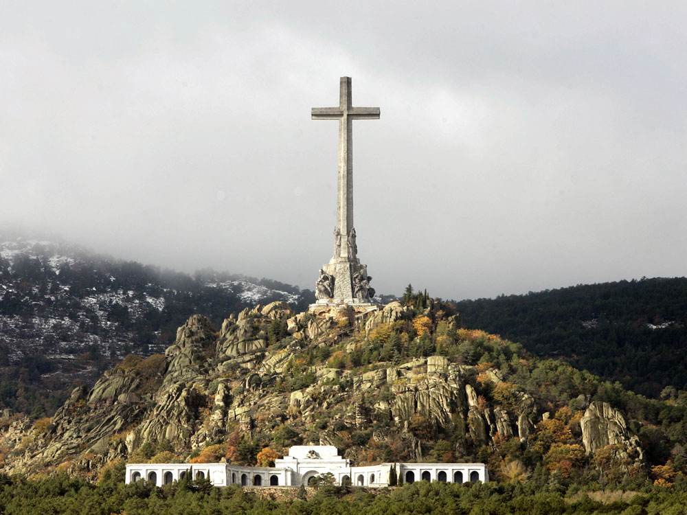 The entrance of the basilica, carved into the rocks, is seen beneath a giant cross where the tomb of Spain's dictator General Francisco Franco lies in the Valle de Caidos (Valley of the Fallen), Spain Wednesday Nov. 16, 2005.  (AP Photo/Paul White)