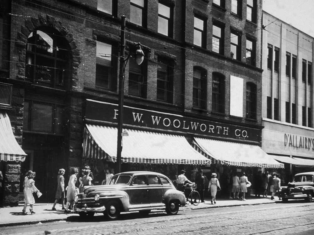 circa 1945: People walk on the sidewalk in front of the F W Woolworth Company department store on a downtown street in Halifax, Nova Scotia.   (Photo by Hulton Archive/Getty Images)