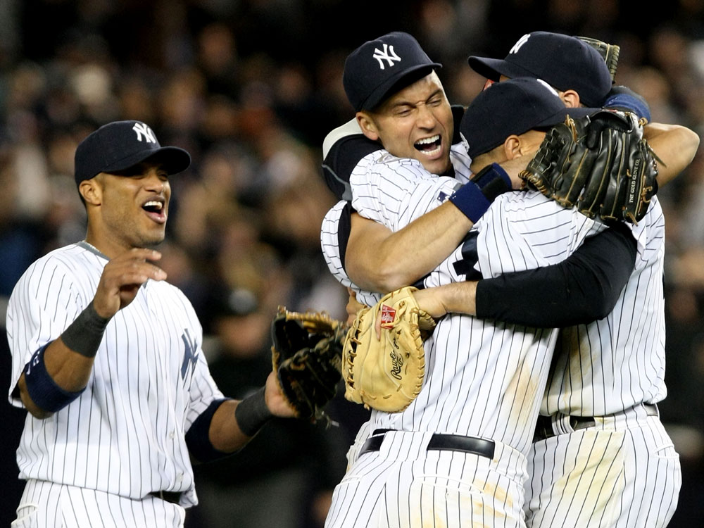 Robinson Cano, Derek Jeter, Mark Teixeira and Alex Rodriguez of the New York Yankees celebrate their 5-2 victory over the Los Angeles Angels of Anaheim at the end of the top of the ninth inning in Game Six of the ALCS during the 2009 MLB Playoffs at Yankee Stadium on October 25, 2009. (Nick Laham/Getty Images)