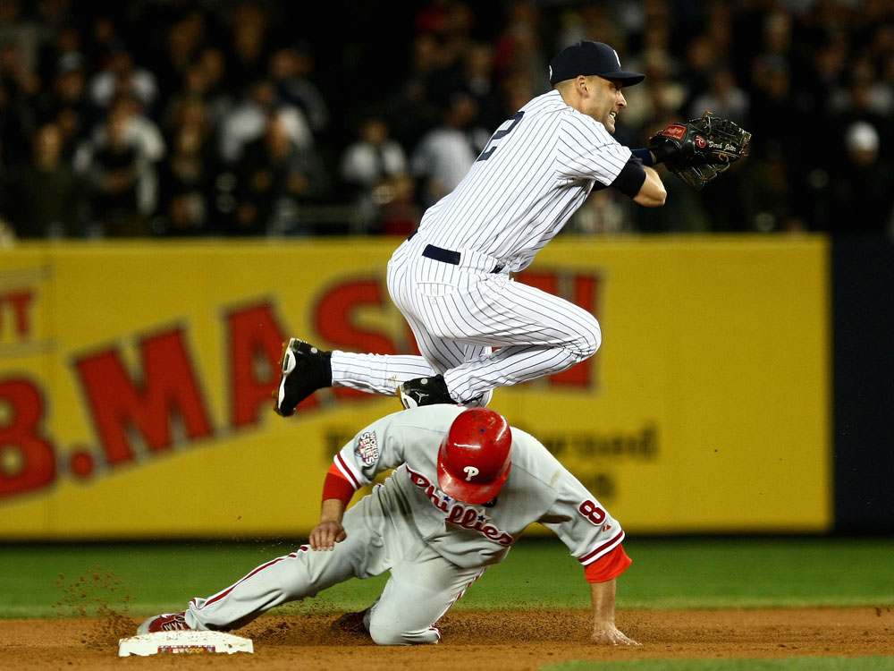 Derek Jeter of the New York Yankees turns a double play against Shane Victorino of the Philadelphia Phillies in Game Two of the 2009 MLB World Series at Yankee Stadium on October 29, 2009 in the Bronx borough of New York City. (Photo by Chris McGrath/Getty Images) 