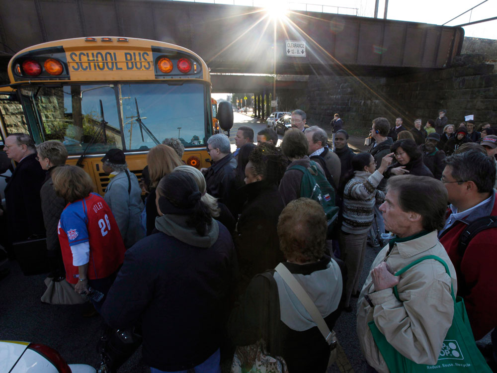 Stranded commuters are loaded on buses near the scene of a train fire in Philadelphia, Wednesday, Nov. 4, 2009. A Philadelphia commuter train caught fire Wednesday, complicating the morning rush already hampered by the city's transit strike. Officials said no injuries were reported. (AP Photo/Matt Rourke)