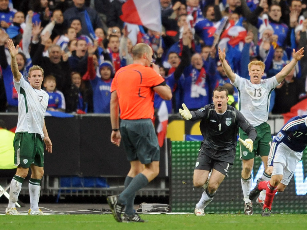  Irish national football team midfielder Liam Lawrence (L), goalkeeper Given (3dR) and defender Paul Mc Shane shout to Swedish referee Martin Hansson (C) as French defender Sebastien Squillaci (R) jubilates after the goal by French defender William Gallas during the World Cup 2010 qualifying football match France vs. Republic of Ireland on November 18, 2009 at the Stade de France in Saint-Denis, northern Paris. Superstar Thierry Henry was at the center of a sensational cheating storm as France reached the World Cup finals along with Portugal, Greece and Slovenia. France, the 1998 champions and 2006 runners-up, drew 1-1 with Ireland at the Stade de France in the second leg of their play-off for a 2-1 aggregate win. But the extra-time triumph came in controversial circumstances when French skipper Henry appeared to control the ball with his hand before his angled pass allowed Gallas to head in the crucial 103rd-minute goal. (Lionel Bonaventure/AFP/Getty Images) 