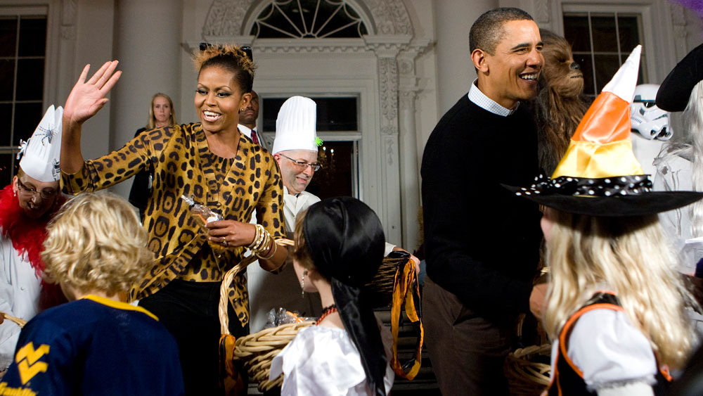 President Barack Obama and first lady Michelle Obama greet parents, trick-or-treaters and local school children at the north portico of the White House during a Halloween celebration on October 31, 2009 in Washington, DC. The Obamas are celebrating their first Halloween in the White House by inviting students and military families over for the holiday. (Photo by Kristoffer Tripplaar-Pool/Getty Images)