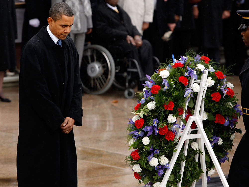 President Barack Obama pauses for a moment of silence after placing a wreath at the Tomb of the Unknowns during a Veterans Day full honor ceremony at Arlington National Cemetery November 11, 2009 in Arlington, Virginia. Obama delivered remarks at the cemetery amphitheater after laying the wreath. (Photo by Chip Somodevilla/Getty Images) 