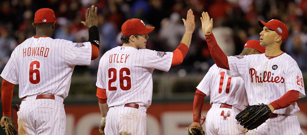From left, Philadelphia Phillies' Ryan Howard, Chase Utley, Jimmy Rollins (11) and Raul Ibanez, right, congratulate themselves after defeating the New York Yankees in Game 5 of the Major League Baseball World Series Monday, Nov. 2, 2009, in Philadelphia. The Phillies won 8-6. The Yankees lead the series 3-2. (AP Photo/David J. Phillip)