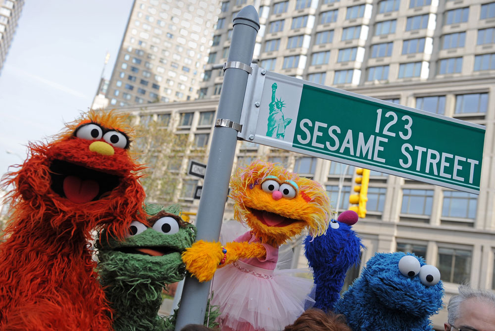 Sesame Street puppet charactors Murray (L), Oscar (2nd L), Zoe (2nd R) and Cookie Monster (R) pose next to temporary street sign November 9, 2009, at West 64th Street and Broadway in New York on the eve of the 40th anniversary of the broadcast of the children's television show. (Stan Honda/AFP/Getty Images)
