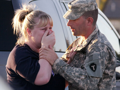 Sgt. Anthony Sills, right, comforts his wife as they wait outside the Fort Hood Army Base near Killeen, Texas on Thursday, Nov. 5, 2009. The Sills' 3-year old son was in daycare on the base, which was in lock-down following a mass shooting earlier in the day. (AP Photo/Jack Plunkett)