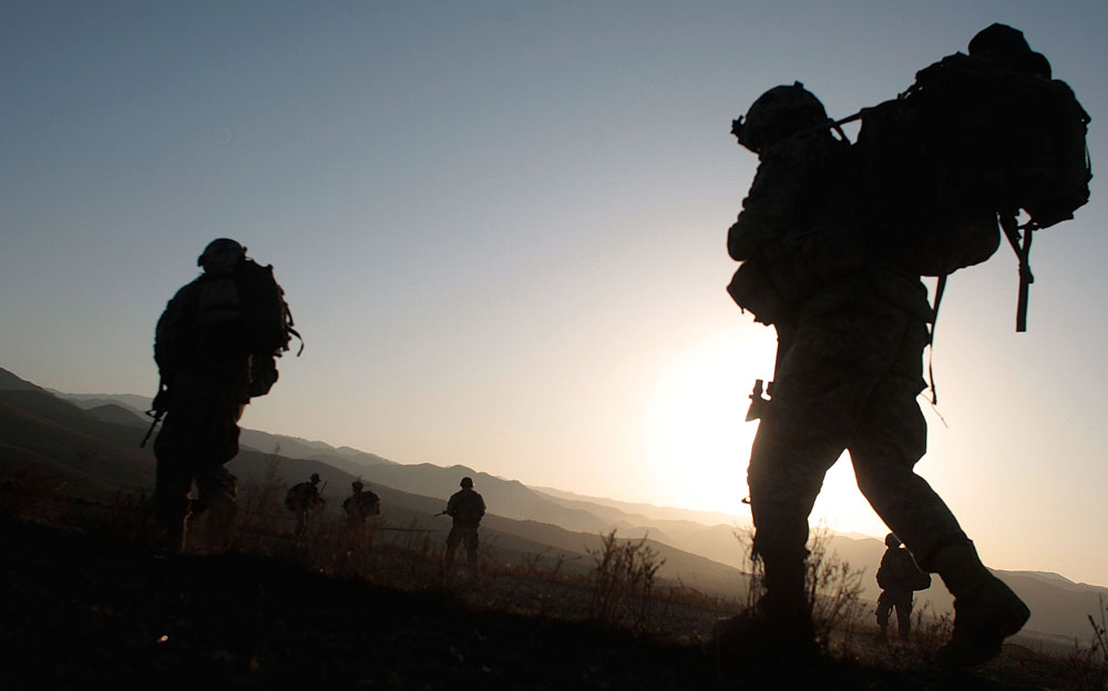 Soldiers of the 1/501st of the 25th Infantry Division begin marching at sunrise just after being air-dropped into a field October 14, 2009 in Paktika Province, Afghanistan. (Photo by Chris Hondros/Getty Images)