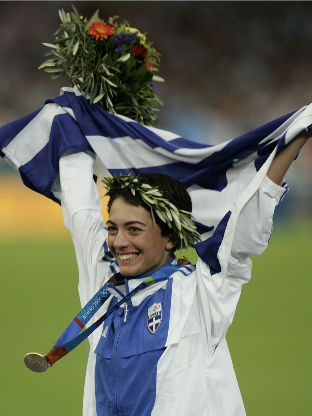 Greece's Athanasia Tsoumeleka, waves her national flag, after being presented with the gold medal fo