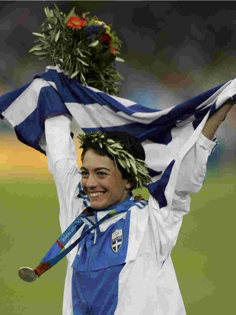 Greece's Athanasia Tsoumeleka, waves her national flag, after being presented with the gold medal fo