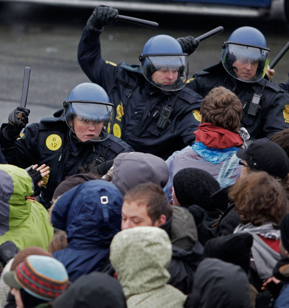 Danish riot police use their batons to push back protesters during a demonstration outside Bella Center, the venue of the U.N. climate change conference, in Copenhagen Wednesday Dec. 16, 2009. The largest and most important climate change conference is underway in Copenhagen, aiming to secure an agreement on how to protect the world from calamitous global warming. (AP Photo/Peter Dejong)