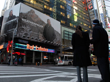 A couple waits to cross the street in front of a billboard ad featuring President Barack Obama wearing a Weatherproof brand jacket Wednesday, Jan. 6, 2010, in Times Square in New York. Outerwear company Weatherproof used a recent news photo of the president in front of the Great Wall in Badaling, China, for the advertisement without permission. (AP Photo/Julie Jacobson)