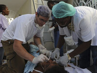 A photo released by Medecins sans Frontieres (MSF) on January 16, 2010 shows a medical team at work in tents in front of what was La Trinit?? trauma hospital and rehabilitation center Pacot in Port-au-Prince on January 15, 2010 following the devastating earthquake. (Photo by Julie Remy/AFP/Getty Images)