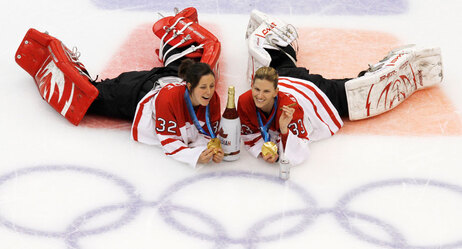 Canada goalies Charline Labonte (32) and Kim St-Pierre (33) pose for a picture at center ice for Marie-Philip Poulin after Canada beat USA 2-0 to win the women's gold medal ice hockey game at the Vancouver 2010 Olympics in Vancouver, British Columbia, Thursday, Feb. 25, 2010. (AP Photo/Gene J. Puskar)