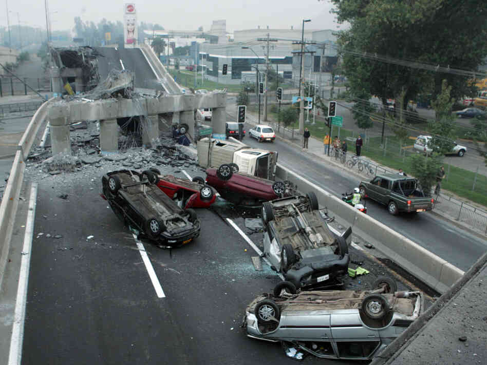 Vehicles that were driving along a highway that collapsed during the earthquake near Santiago are se