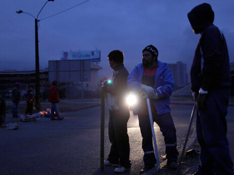People stand outside their homes, guarding them from looters in Concepcion, Chile, Monday, March. 1, 2010. The government sent soldiers to Concepcion and ordered a nighttime curfew to quell looting after an 8.8-magnitude earthquake struck central Chile early Saturday. (AP Photo/Natacha Pisarenko)