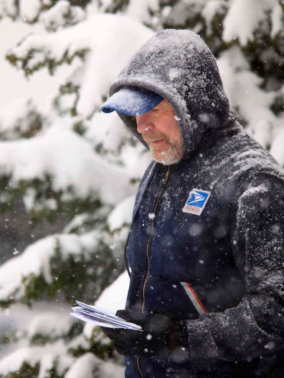 U. S.Post Office letter carrier Tim Bell delivers the mail during a snow storm in Havertown, Pa. Sat