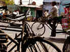 Iron bikes, which fill Indian roads, stand for sale as traffic rolls by a busy street in Aligarh. (K Iron bikes, which fill Indian roads, stand for sale as traffic rolls by a busy street in Aligarh. (K