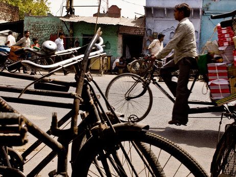 Iron bikes, which fill Indian roads, stand for sale as traffic rolls by a busy street in Aligarh. (Kainaz Amaria for NPR)