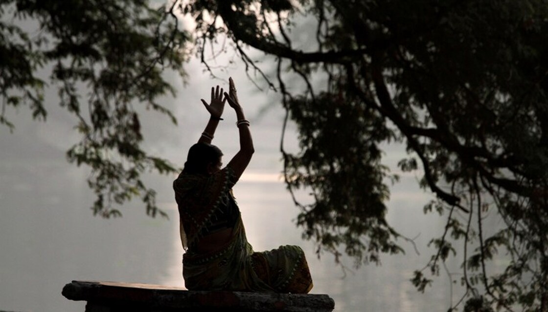 A woman performs exercises early morning at a park in Calcutta, India, Friday, March 19, 2010. (AP P