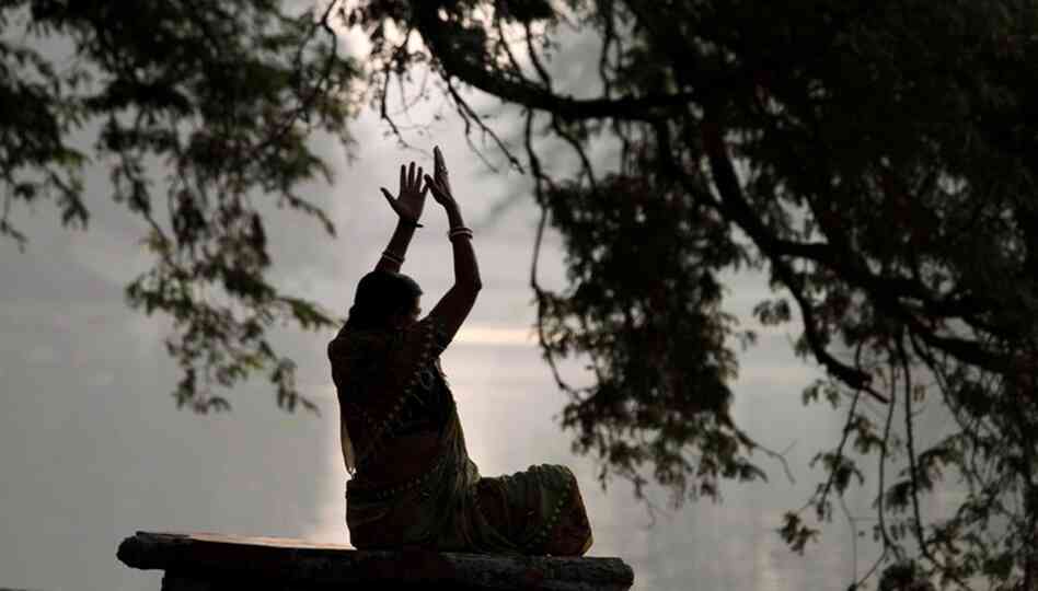 A woman performs exercises early morning at a park in Calcutta, India, Friday, March 19, 2010. (AP P