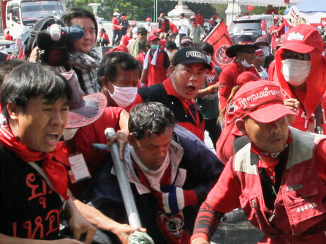 In this April 10, 2010 file photo, Japanese cameraman Hiro Muramoto, 43, upper center, films Thai anti-government demonstrators as they clash with soldiers near the United Nations complex in Bangkok, Thailand. Muramoto was killed by a gunshot to the chest later in the day. (AP Photo/David Longstreath)