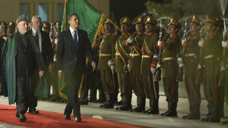 President Barack Obama walks with Afghan President Hamid Karzai during a welcoming ceremony at the Presidential Palace in Kabul on March 28, 2010. (Photo by Jim Watson/AFP/Getty Images)