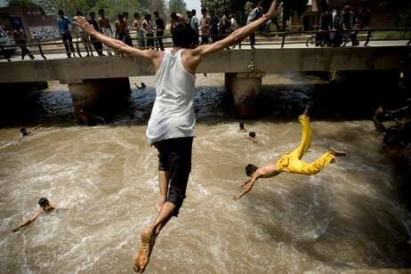 Pakistani men jump into a water canal to take a reprieve from the heat in Lahore, Pakistan, on Sunday, May 4, 2008. (AP Photo/Emilio Morenatti)