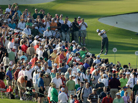 Spectators surround Tiger Woods as he tees off during a practice round for the Masters golf tournament in Augusta, Ga., Monday, April 5, 2010. The tournament begins Thursday, April, 8. (AP Photo/David J. Phillip)
