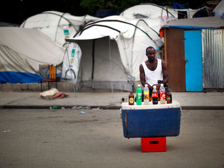 A man sells cold drinks outside of a refugee camp near the collapsed presidential palace in downtown Port-au-Prince Haiti Tuesday May 4, 2010. Many of the people displaced by January's earthquake are still living in make shift shelters on the streets. (David Gilkey/NPR)