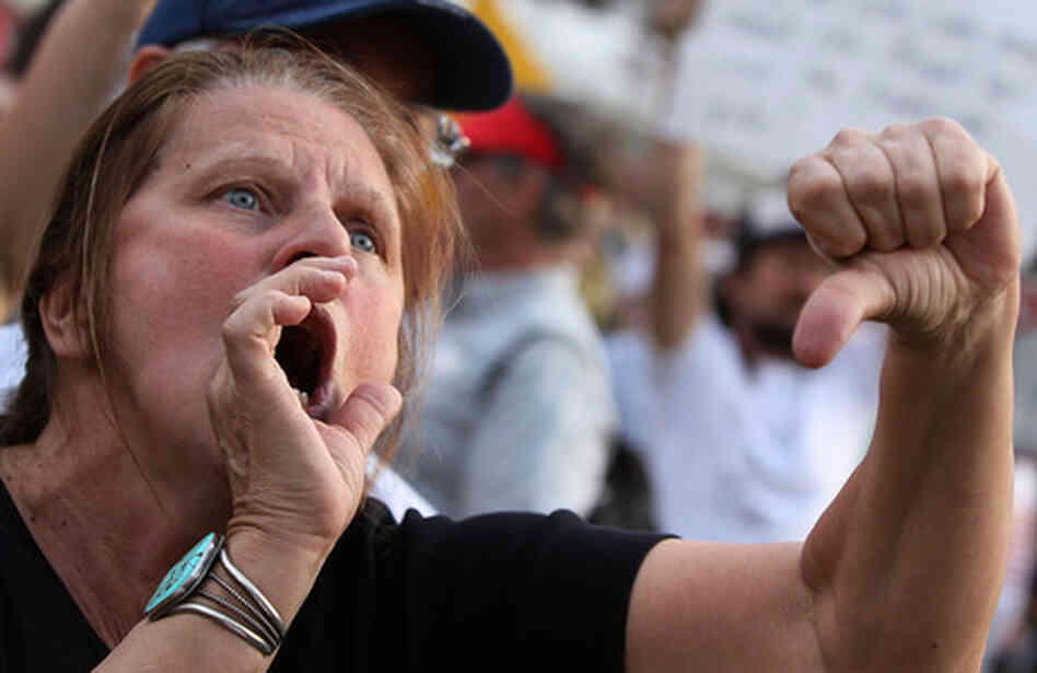 Protester shouting and making thumbs down gesture. Protester shouting and making thumbs down gesture.