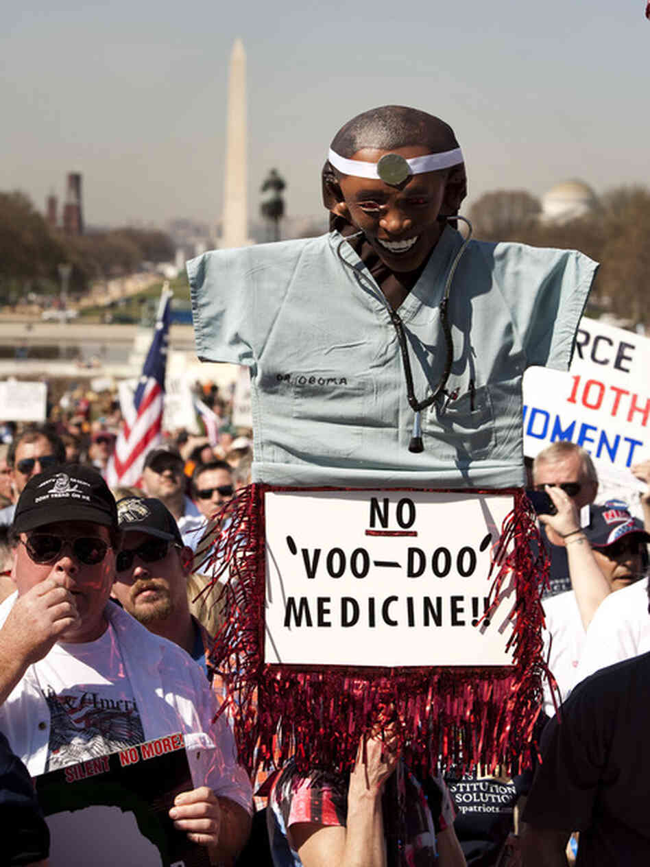 Protester carrying sign of Obama as voo doo doctor Protester carrying sign of Obama as voo doo doctor