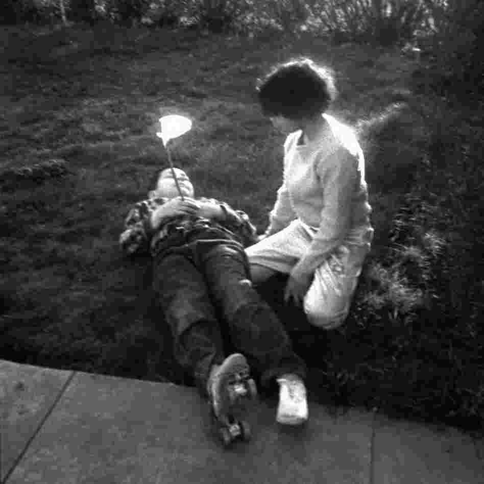 Two children and lily, by Joanne Leonard and Judith Fuss Adell, circa 1960.  Leonard considers this her first photograph, taken when she was learning the trade at a local high school.