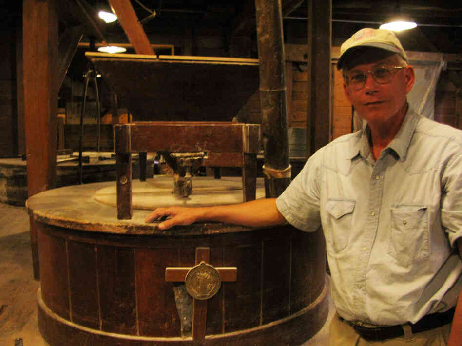 Brother Francis is the Miller at the Saint Vincent Gristmill.  He's pictured here next to one of two one-ton burhstones, brought from France by the monastery's founders in 1846, which are used to grind wheat into flour.