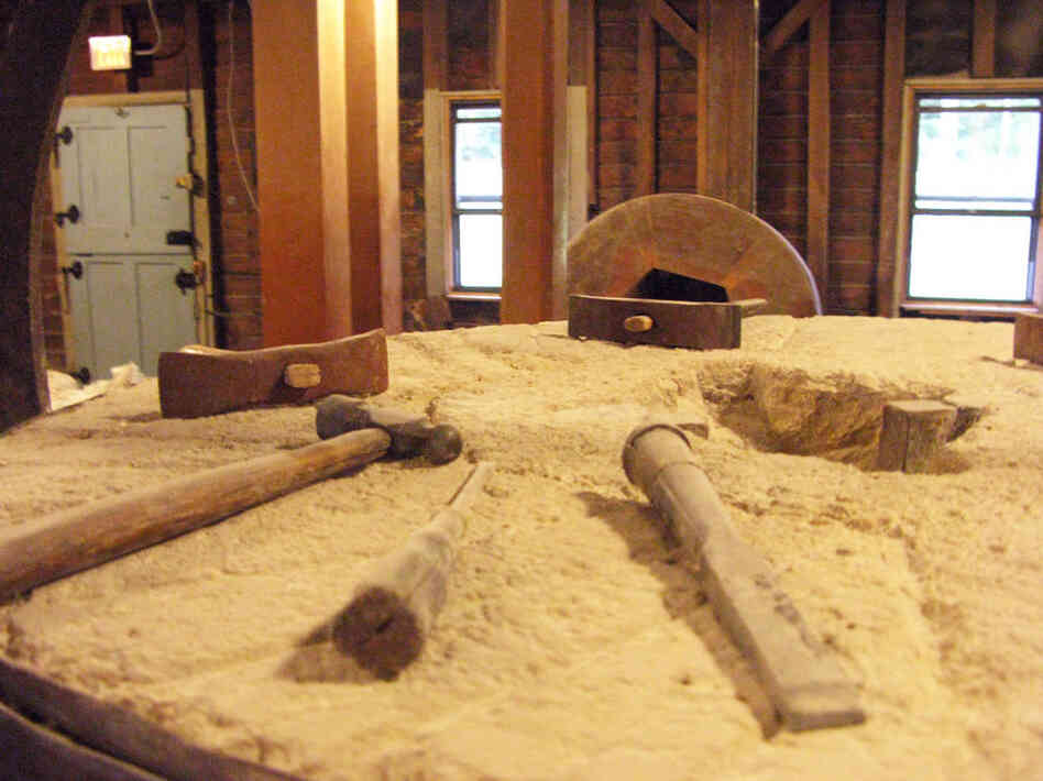 Tools rest on a flour-covered burhstone in the mill.  The craftmanship used in the milling process has gone largely unaltered since 1854.  Only the method of power has changed — from coal to electric.