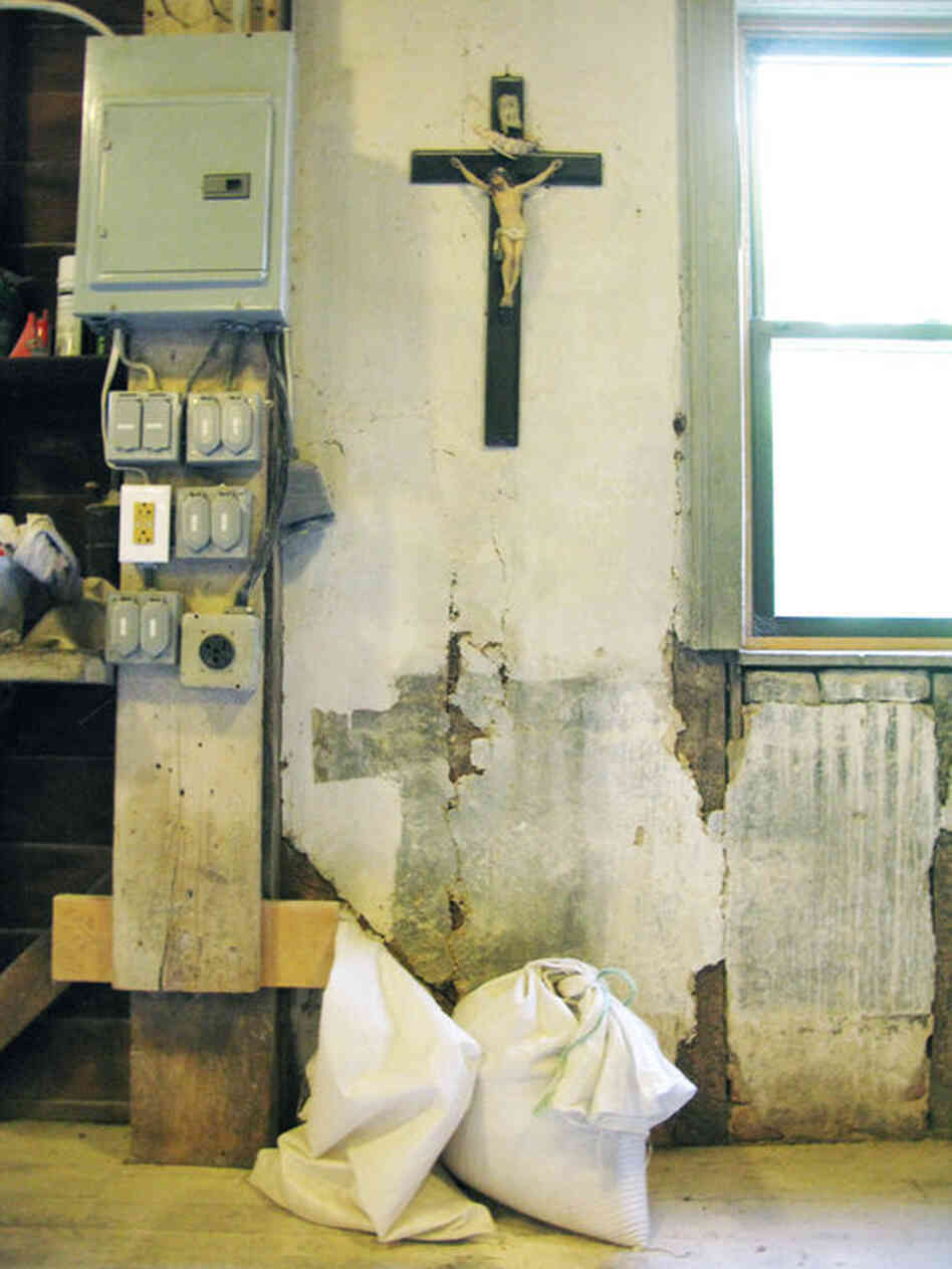 A crucifix hangs on the wall above bags of flour in the Saint Vincent Gristmill.