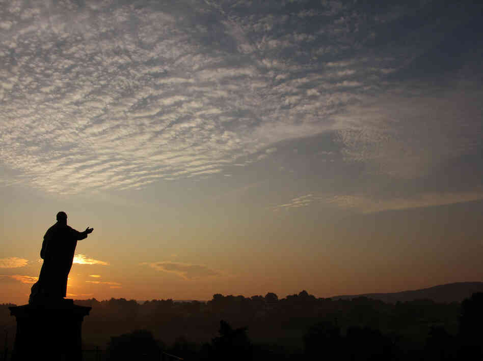 The sun rises in Latrobe, Pennsylvania behind a statue of Archabbot Boniface Wimmer, who founded the Saint Vincent Archabbey in 1846.  It shares a home with St. Vincent College.