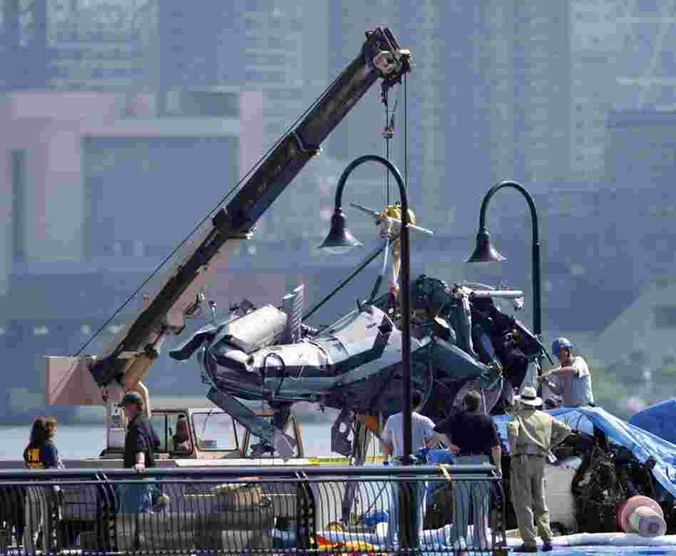 The wreckage of a helicopter is repositioned by a crane on a pier in Hoboken, N.J., Monday. The helicopter was hit by a small plane Saturday and fell into the Hudson River between New York and New Jersey. On Monday, search crews were still trying to recover the bodies of two of nine people killed. 