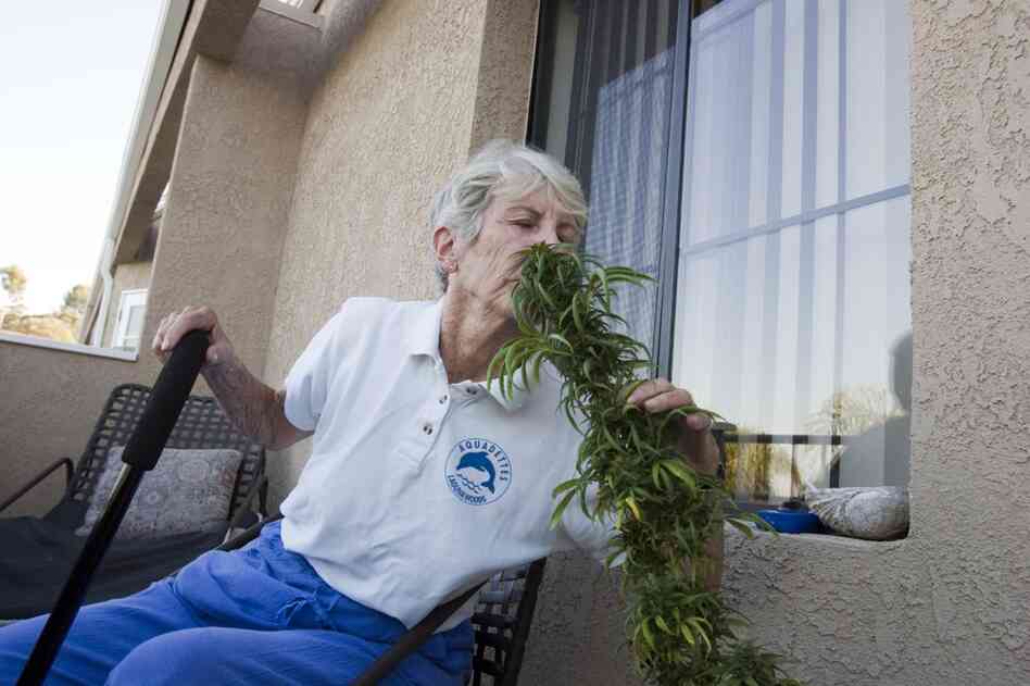 Margo Bouer, an advocate for medical marijuana, sniffs a plant she's grown on the deck of her home in Laguna Woods, Calif. 